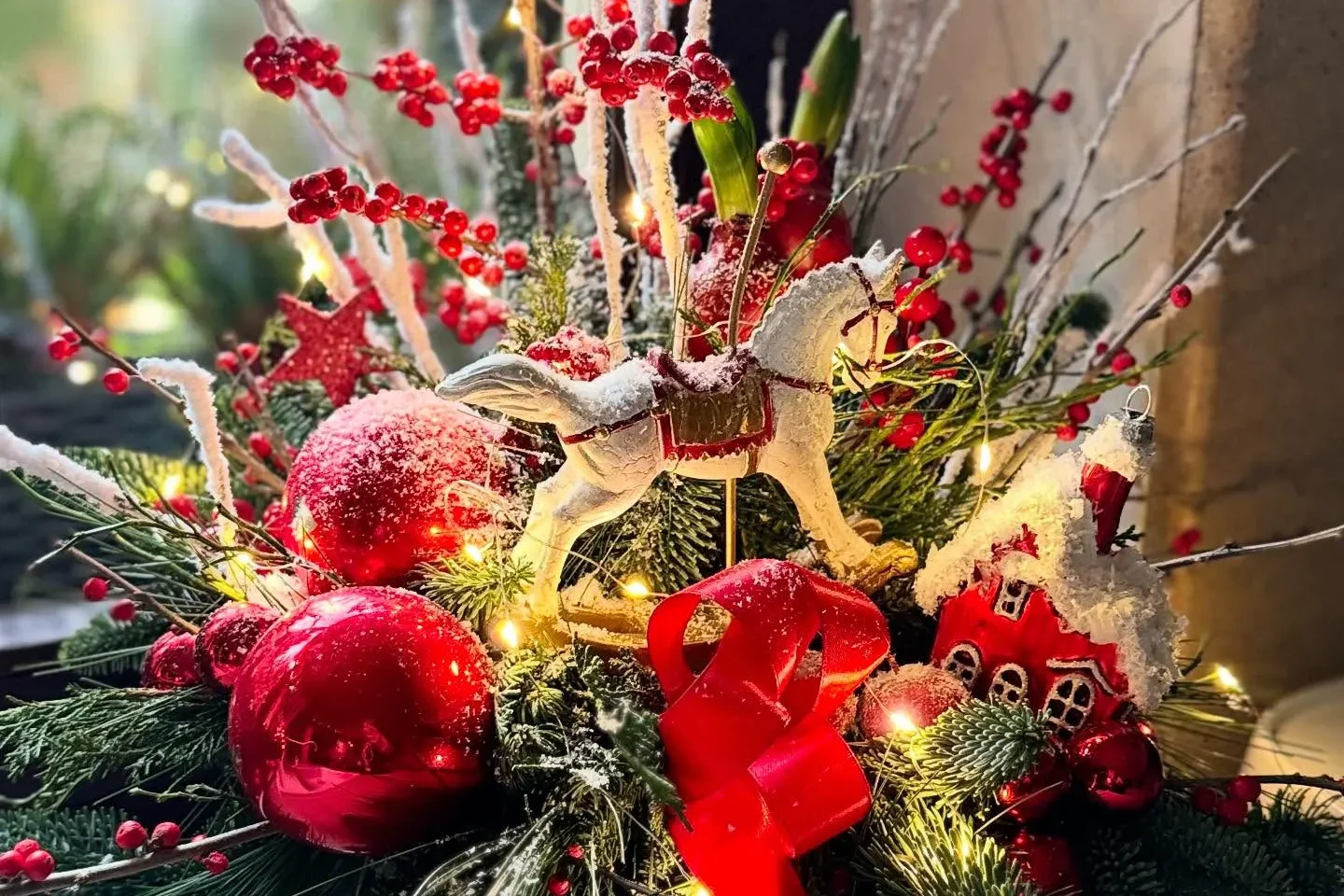 Świąteczna kompozycja florystyczna z czerwonymi bombkami, gałązkami i dekoracjami