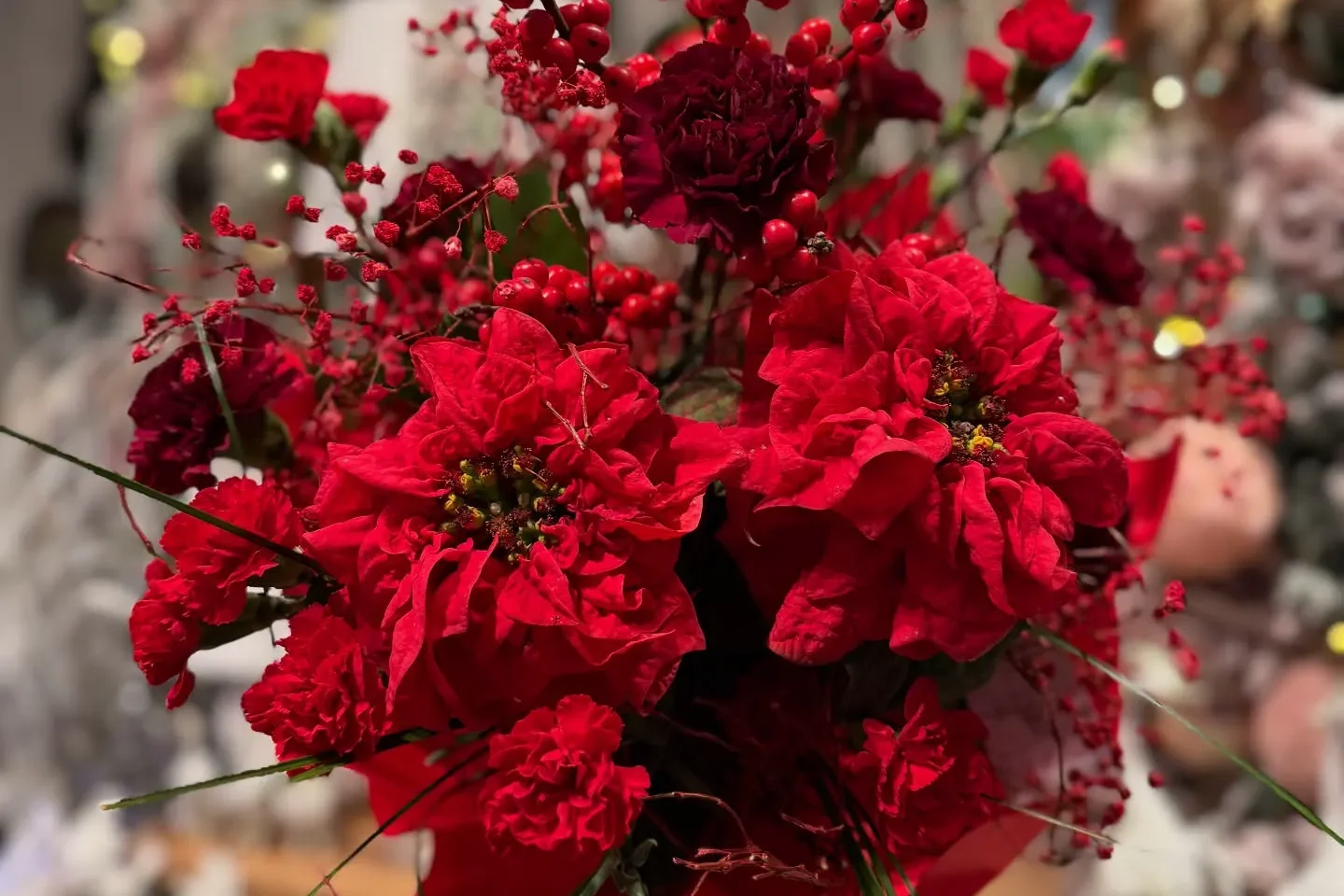 Czerwony zimowy bukiet z kwiatów i dekoracyjnych owoców we wnętrzu