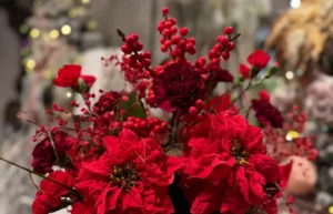 Czerwony zimowy bukiet z kwiatów i dekoracyjnych owoców we wnętrzu